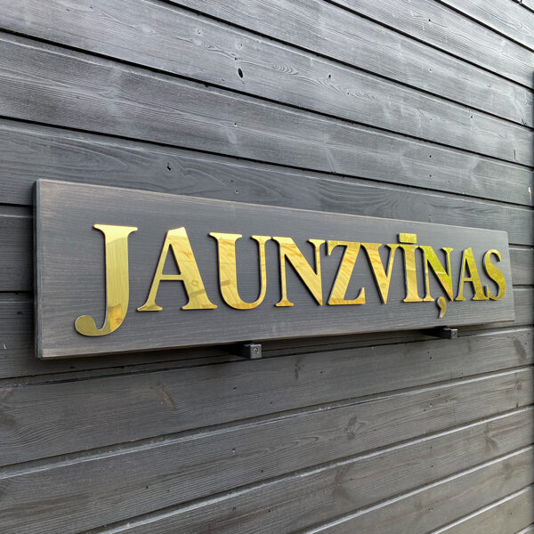 Mājas norāde ar zelta burtiem 