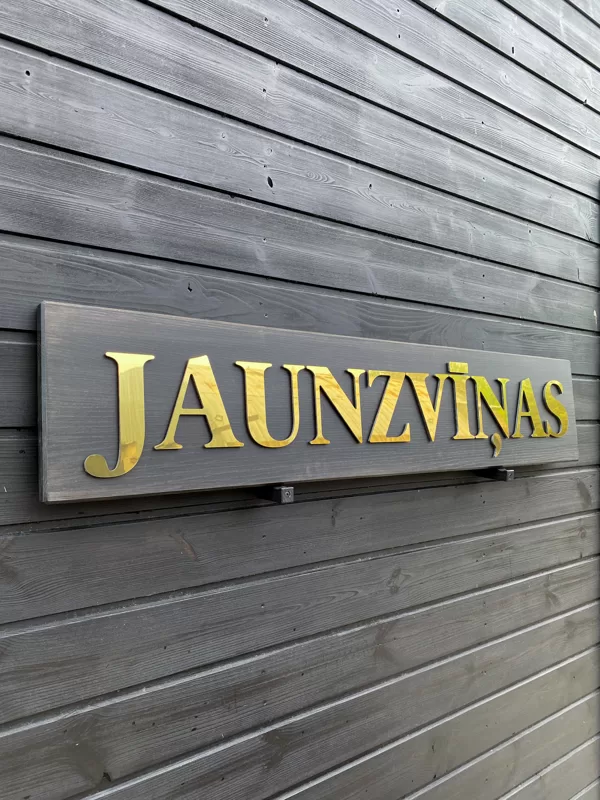 Mājas norāde ar zelta burtiem 